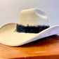 A feather hat band featuring black & iridescent feathers. This item contains straps.