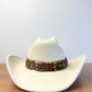 A feather hat band with brown and caramel feathers. This item comes with straps.