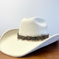 A feather hat band featuring white spots on brown feathers. This band comes with straps.