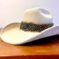 A feather hat band with black & white feathers featuring white dots and baby blue accents. This item comes with straps.