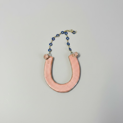 Ceramic Horseshoe Wall Hanging. Made from ceramic, this one of a kind piece adds a touch of rustic charm to any room. Enhance your space with this hand-crafted horseshoe, a symbol of good luck and protection.