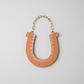 Ceramic Horseshoe Wall Hanging. Made from ceramic, this one of a kind piece adds a touch of rustic charm to any room. Enhance your space with this hand-crafted horseshoe, a symbol of good luck and protection.