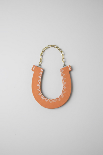Ceramic Horseshoe Wall Hanging. Made from ceramic, this one of a kind piece adds a touch of rustic charm to any room. Enhance your space with this hand-crafted horseshoe, a symbol of good luck and protection.